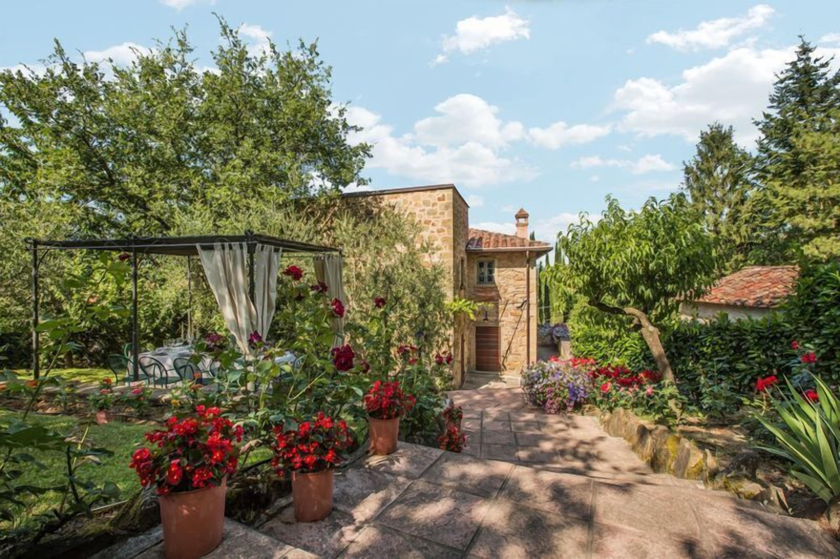 A stone house with a garden path leading to a door.