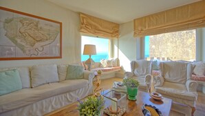 A cozy living room with a large map on the wall, comfortable seating, and a view of the outdoors. - Presidio (Orbetello)