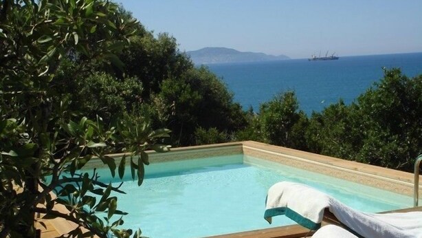 A pool with a view of the sea and mountains, surrounded by greenery. - Presidio (Orbetello)