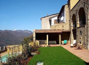 Un edificio de piedra con un patio y una piscina.