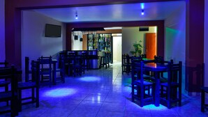 A restaurant with multiple tables and chairs, a bar area, and a tiled floor. - Matryoshka (Ica)