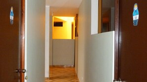 A hallway with wooden doors, a patterned floor, and a ceiling light. - Matryoshka (Ica)