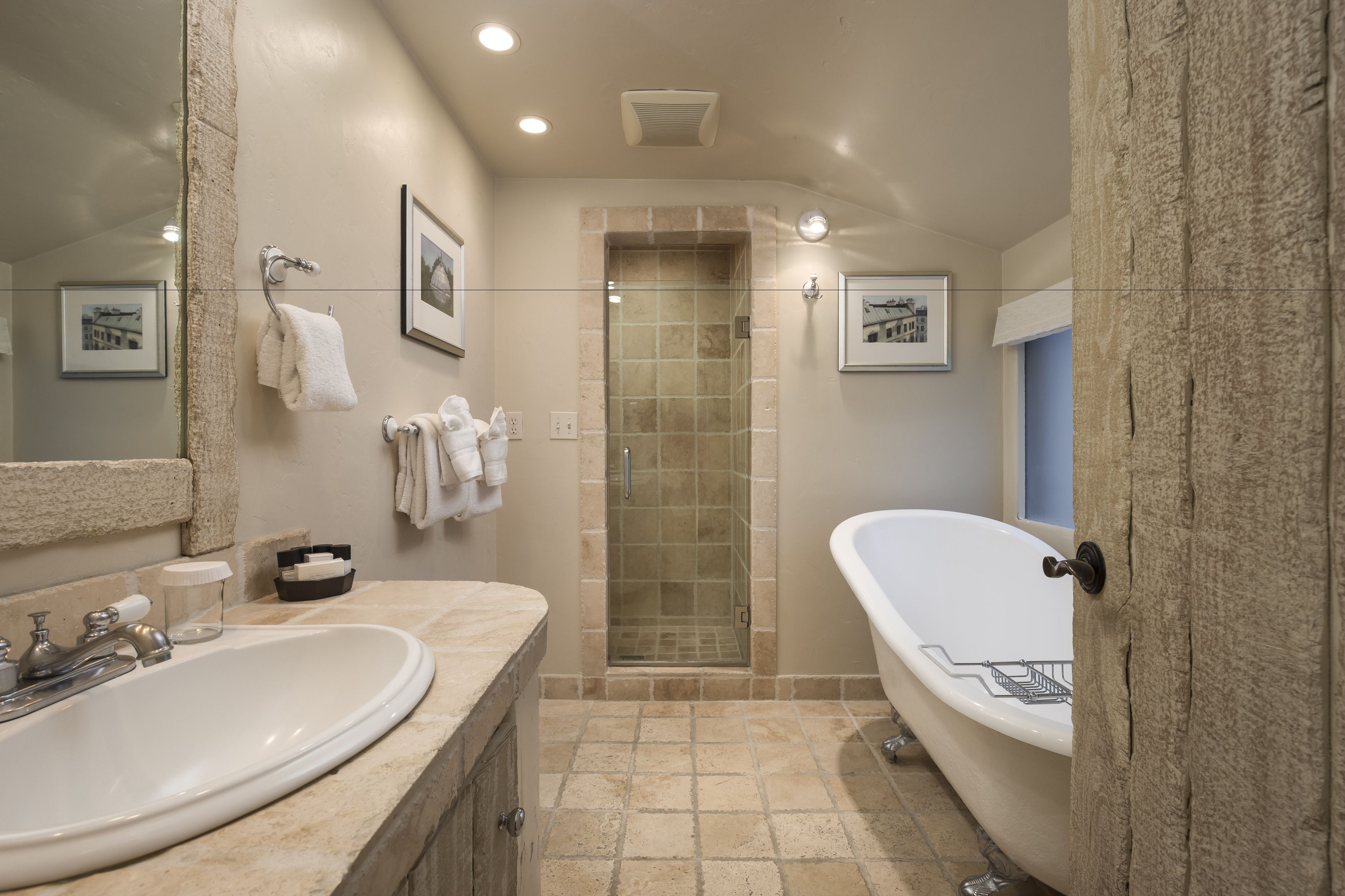A bathroom with a large sink, a bathtub, and a shower area.