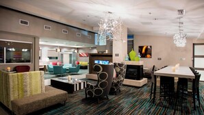 A modern hotel lobby with a patterned carpet, contemporary furniture, and a large chandelier. - Residence Inn Lake Charles (Lake Charles)