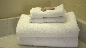 A stack of white towels in a bathroom corner. - Lambert Inn (Kissimmee)