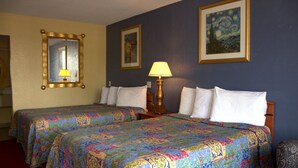 A hotel room with two beds, a lamp, a mirror, and a painting on the wall. - Lambert Inn (Kissimmee)