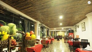 A restaurant with a wooden ceiling, marble floor, and tables with red tablecloths. - Galaxy Angkor Boutique Hotel (Siem Reap)