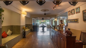 A hotel reception area with a counter, seating area, and a view of the outdoors. - Galaxy Angkor Boutique Hotel (Siem Reap)