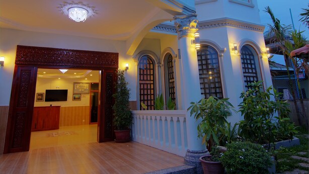A grand building with a large entrance, multiple balconies, and potted plants. - Serkirin Mary Angkor Villa (Siem Reap)