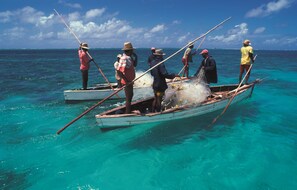 A group of people on a small boat in clear turquoise water. - Reve des Iles (Rodrigues Island)