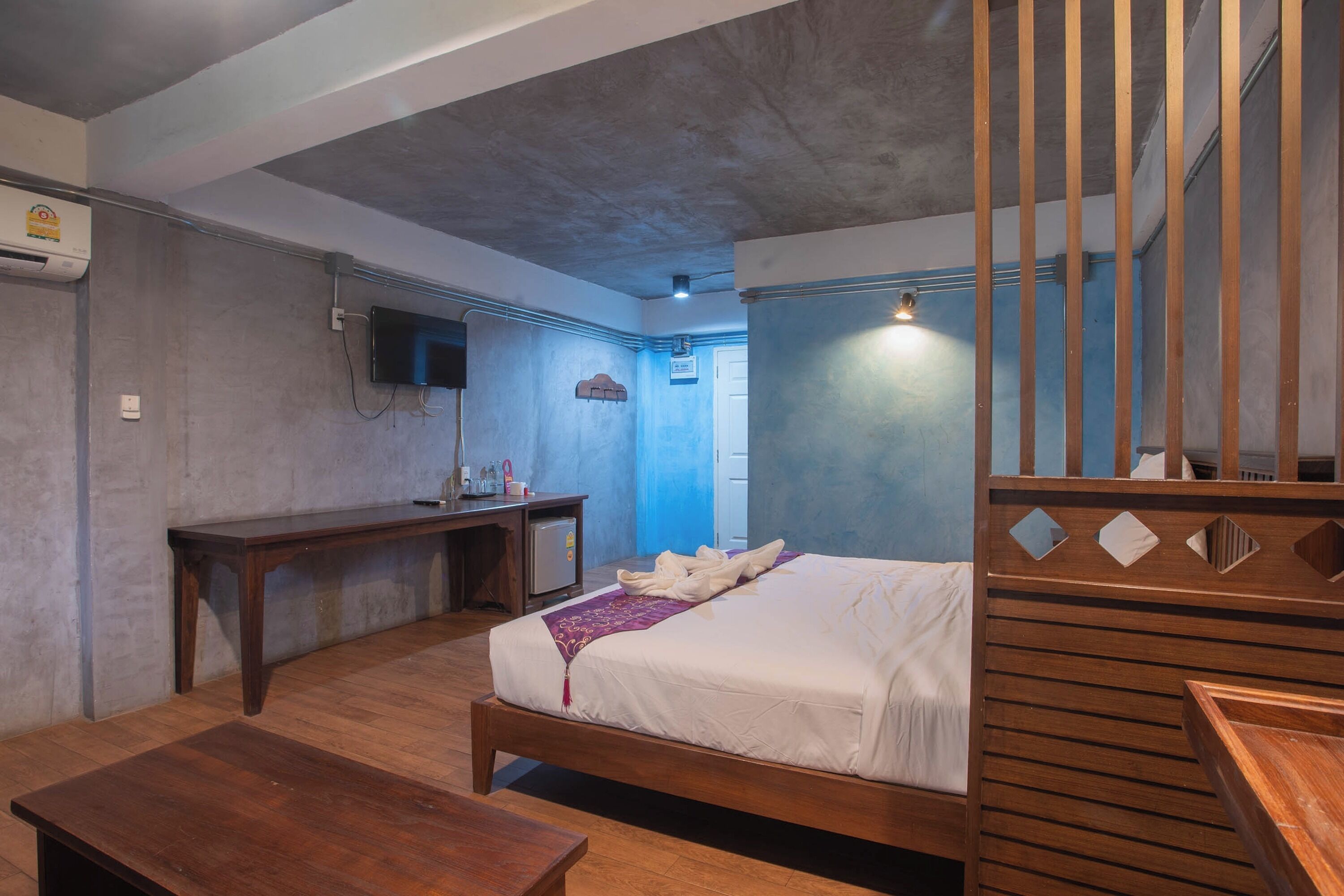 A bedroom with a wooden bed, a desk, and a television.