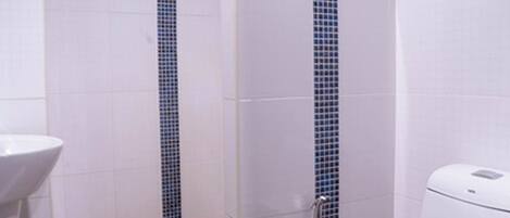Un baño con ducha, inodoro y lavamanos.