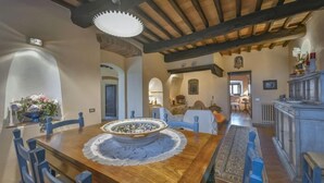 A dining area with a wooden table, blue chairs, and a decorative bowl centerpiece. - Villa Casalguidi (Serravalle Pistoiese)