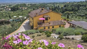 A yellow villa with a balcony, surrounded by lush greenery and a view of distant mountains. - Villa Casalguidi (Serravalle Pistoiese)