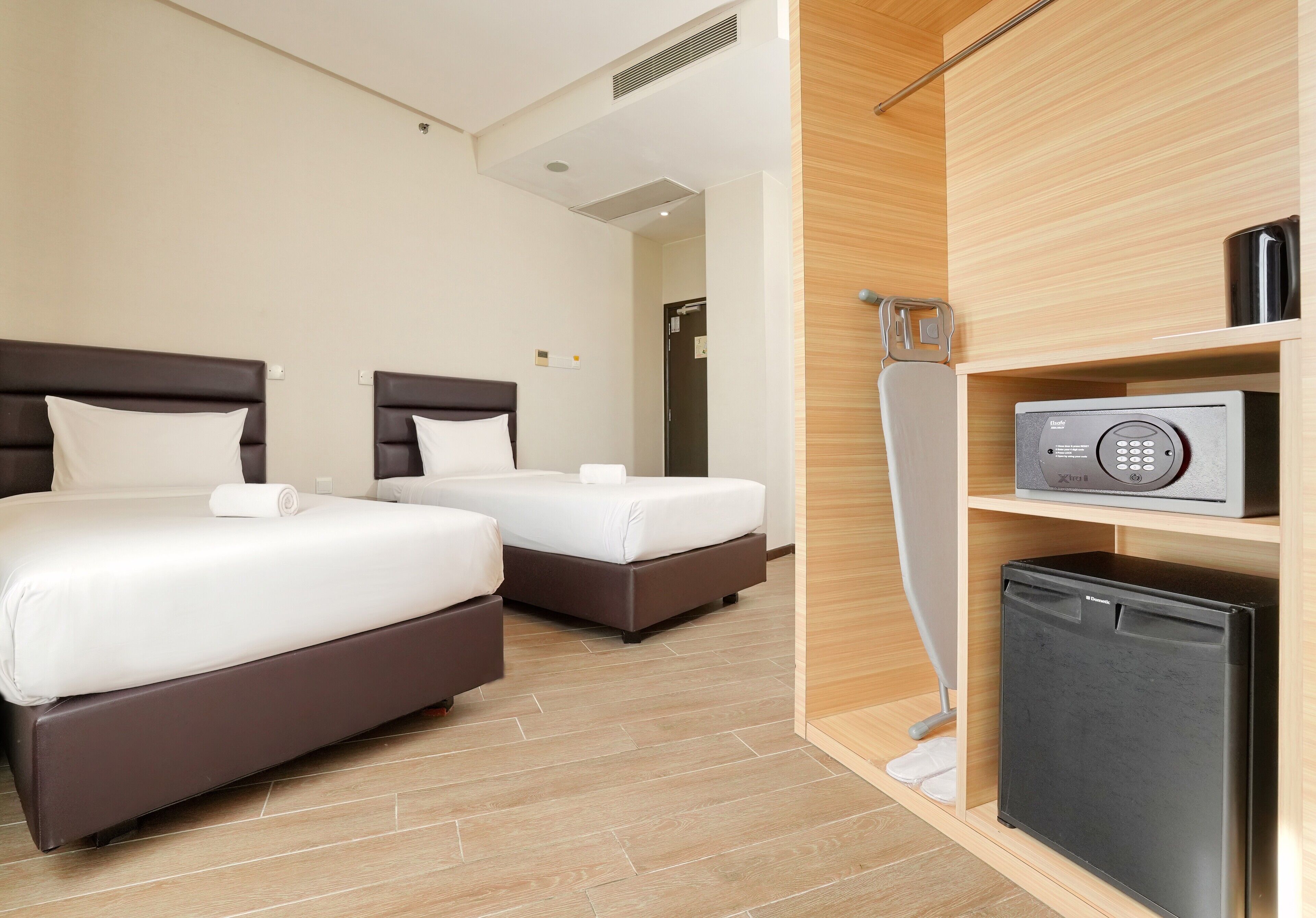 Ett hotellrum med två sängar, en mikrovågsugn och ett litet kylskåp.