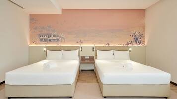 A hotel room with two beds, a large mural on the wall, and a small table between the beds.