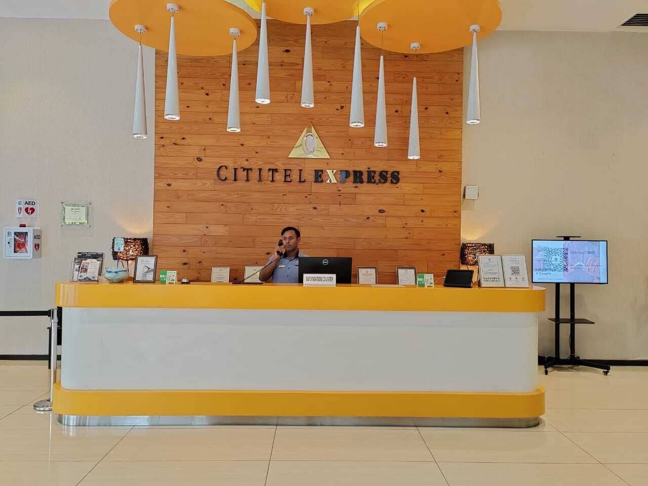 A reception desk with a wooden backdrop and a sign that reads "CITITEL EXPRESS".