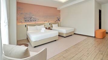 Una habitación de hotel moderna con dos camas, una zona de estar y un mural en la pared.