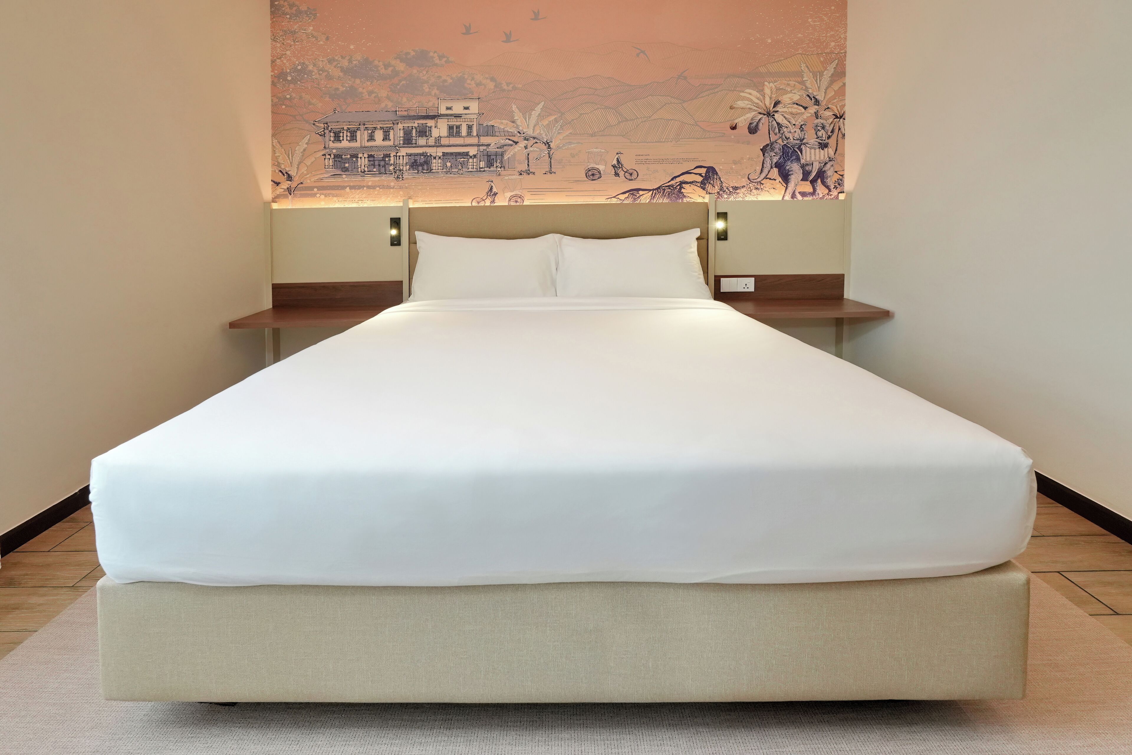 A neatly made bed with a white sheet and a beige mattress in a hotel room.