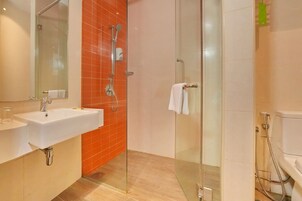 Ein modernes Badezimmer mit einer Duschkabine, einem weißen Waschbecken und einer Toilette.