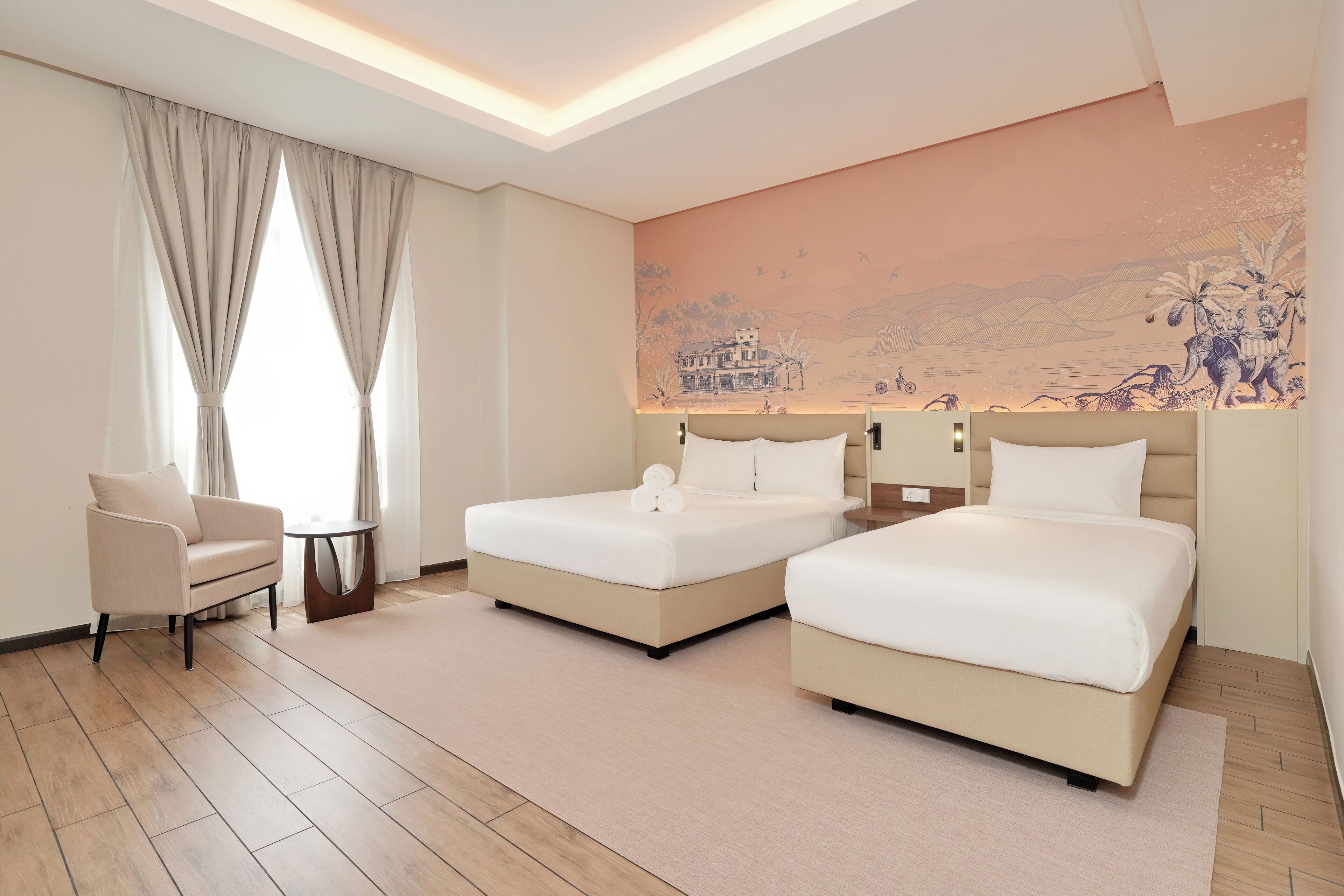 A hotel room with two beds, a sofa, a small table, and a large mural on the wall.