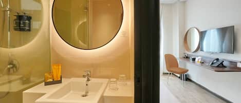 A modern bathroom with a large mirror, a sink, and a shower area.