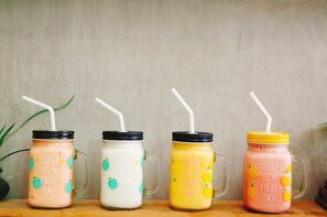 Fire glas med sugerør, hvor hvert glas er mærket 'I dag er det frugtdag' og indeholder smoothies med forskellig farve frugt.