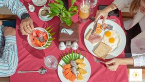 A breakfast setting with plates of food, a plant, and a bottle of juice on a table. - Best Central Point Hotel (Phnom Penh)