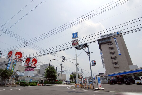 A commercial area with a building featuring a blue sign, multiple power lines, and a traffic light.