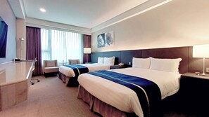 A hotel room with two beds, a desk, a chair, a lamp, and a painting on the wall. - HiYesHotel - Hualien (Hualien City)
