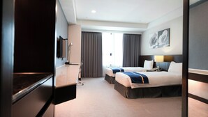 Une chambre d’hôtel avec deux lits, une télévision, un bureau et une fenêtre avec des rideaux.