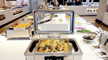 A buffet setup with various food items and utensils.