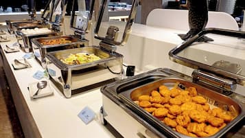A buffet setup with various food items and utensils.