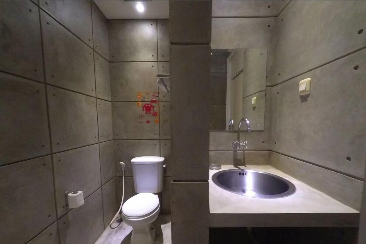 A bathroom with a toilet, sink, and mirror.