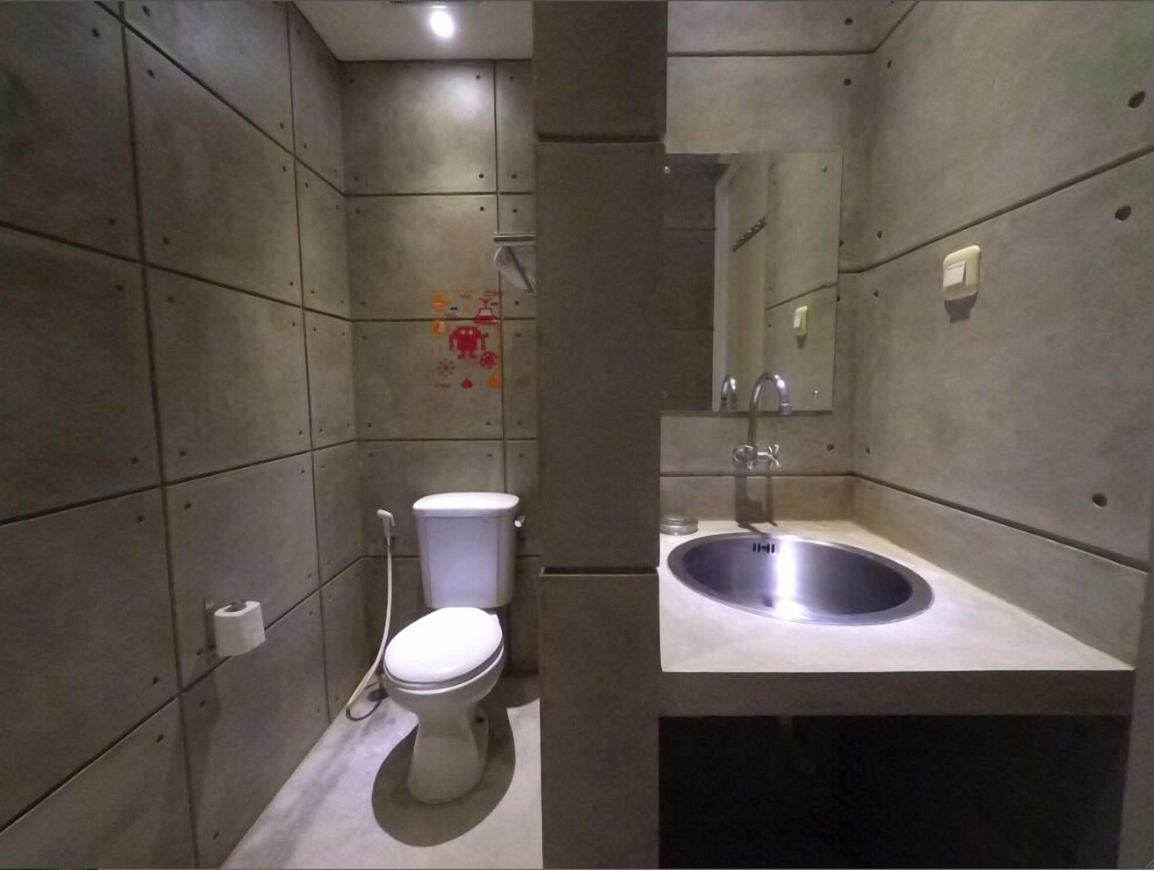 A modern bathroom with a toilet, sink, and mirror.