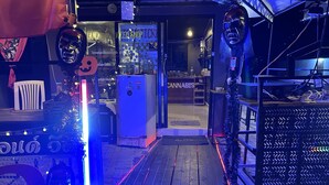 Un escaparate con un letrero de cannabis, un refrigerador y un árbol de Navidad.