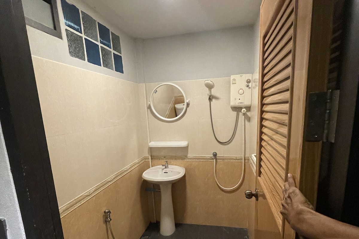 A small bathroom with a toilet, sink, and shower.