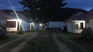 Una hilera de edificios de una sola planta con un sendero de tierra que lleva a una zona central.