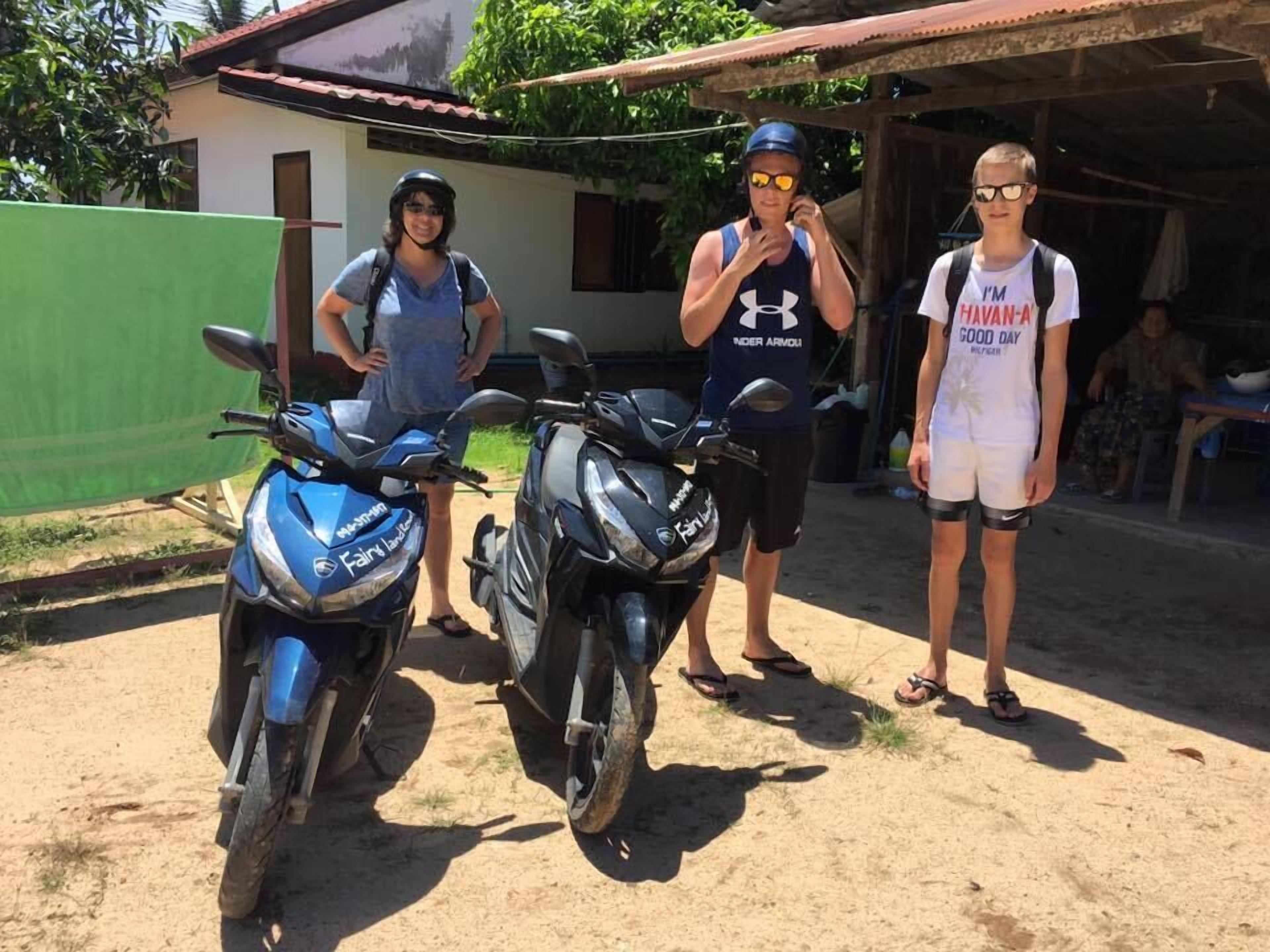Two motorcycles parked outside a building with a corrugated metal roof.