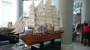 A model ship displayed indoors, with a large window in the background. - Atlantis Residence - Huge Saltwater Waterpark, Gym & Kids Playground - Free Parking (Pattaya)