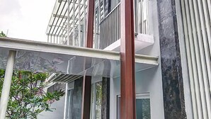 A modern building with a glass balcony, a staircase, and a door.