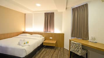 Una habitación de hotel con cama, mesita de noche, silla y escritorio con espejo.
