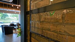 The interior of the De Parkview Hotel with a brick wall, a reception desk, and seating area. - De ParkView Hotel (Ipoh)