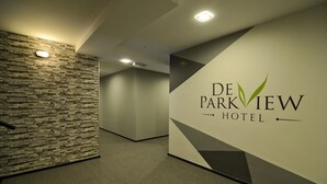 A hallway with a stone wall and a sign for De Parkview Hotel. - De ParkView Hotel (Ipoh)