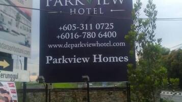 A billboard for De Parkview Hotel with contact information and the website www.deparkviewhotel.com.