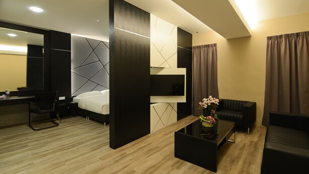 A modern hotel room with a bed, a desk, a TV, a sofa, and a coffee table. - De ParkView Hotel (Ipoh)