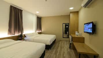 Habitación de hotel con dos camas, televisión, escritorio y espejo.