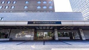 Entrada do Hotel Cadena Tokyo, com design moderno, destacando uma fachada imponente com portas de vidro e vista clara do entorno urbano.
