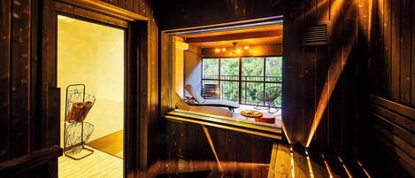 A wooden interior with a bench, a window, and a chair with a metal frame.