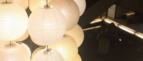 A series of spherical paper lanterns hanging from the ceiling in a well-lit indoor space.